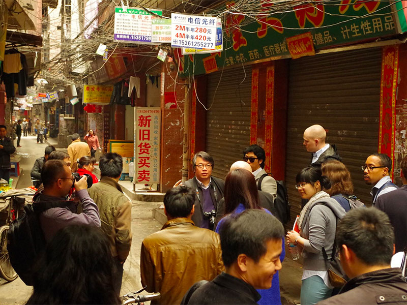 Students stand in a shopping street during a trip to China.